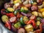 One-pan honey garlic kielbasa with roasted vegetables coated in a glossy sweet and savory sauce.