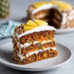 Moist carrot pineapple cake topped with creamy frosting and bits of crushed pineapple.