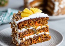 Moist carrot pineapple cake topped with creamy frosting and bits of crushed pineapple.