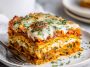 A golden-baked layered lasagna made with sweet potatoes, butternut squash, carrots, creamy sauce, and melted cheese, served in a casserole dish.