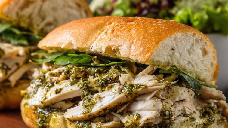 Toasted chicken pesto sandwich with juicy chicken, basil pesto, and melted cheese.
