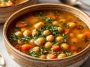 Warm vegan garlic chickpea soup with tender chickpeas, herbs, and a rich, flavorful broth served in a bowl.
