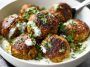 Baked Greek lentil meatballs served with creamy tzatziki sauce, fresh herbs, and a side of vegetables.