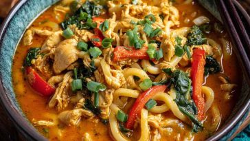 Udon noodles with chicken in creamy coconut red curry sauce, rich and flavorful.