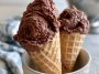 Creamy brownie batter ice cream scooped into a bowl with chocolate brownie chunks and chocolate drizzle on top.
