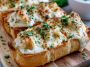 Chicken Alfredo garlic bread topped with melted cheese and creamy sauce.