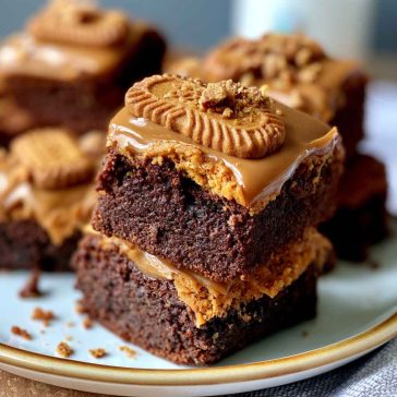 Fudgy Biscoff brownies with swirls of cookie butter on top, cut into squares with a rich, gooey center.