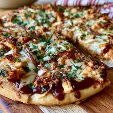 BBQ chicken pizza topped with grilled chicken, red onions, melted cheese, and tangy barbecue sauce on a crispy crust.