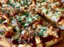 BBQ chicken pizza topped with grilled chicken, red onions, melted cheese, and tangy barbecue sauce on a crispy crust.