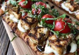 Chicken Caprese flatbread topped with mozzarella, tomatoes, basil, and balsamic glaze.