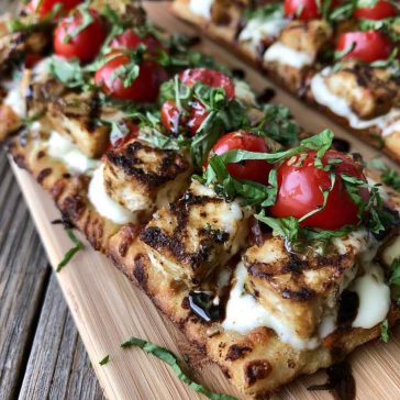 Chicken Caprese flatbread topped with mozzarella, tomatoes, basil, and balsamic glaze.