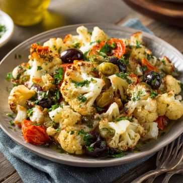 Marinated cauliflower salad with fresh vegetables and Mediterranean herbs.