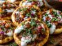 Mini lahmacun bites topped with spiced meat and yogurt drizzle.