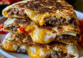 Crispy smashburger quesadillas filled with seasoned ground beef, melted cheese, and sauce, toasted until golden and sliced into wedges.