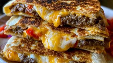 Crispy smashburger quesadillas filled with seasoned ground beef, melted cheese, and sauce, toasted until golden and sliced into wedges.