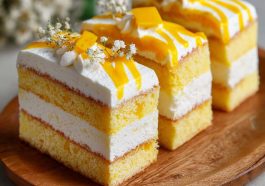 Moist mango milk cake topped with fresh mango pieces and creamy layers.