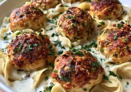 Chicken ricotta meatballs simmered in creamy Alfredo sauce served in a skillet