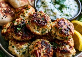 Chicken kofta served with creamy garlic yogurt sauce and herbs.