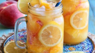 Refreshing beach peach lemonade with fresh peaches and lemon slices in a chilled glass with ice.