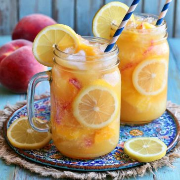 Refreshing beach peach lemonade with fresh peaches and lemon slices in a chilled glass with ice.