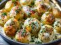 Creamy garlic sauce baby potatoes coated in a rich sauce with herbs, served warm in a bowl.