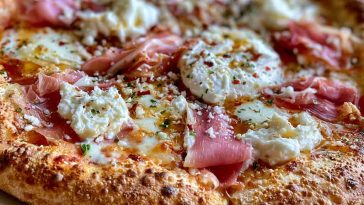 Gourmet prosciutto honey burrata pizza topped with creamy burrata cheese, thin prosciutto slices, fresh herbs, and a drizzle of honey.