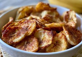 Crispy air fryer banana chips coated in cinnamon sugar, arranged in a bowl for a healthy homemade snack.