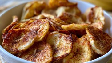 Crispy air fryer banana chips coated in cinnamon sugar, arranged in a bowl for a healthy homemade snack.