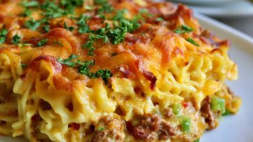 Cheesy hearty casserole baked golden and served warm on a plate.