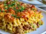 Cheesy hearty casserole baked golden and served warm on a plate.