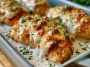 Juicy sour cream and onion chicken baked in a creamy sauce with golden crispy topping, garnished with herbs.