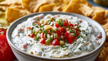 Creamy pickle de gallo ranch dip with chopped pickles and herbs.