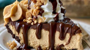 Chocolate peanut butter pie with a creamy peanut butter filling and rich chocolate topping, served in a slice with whipped cream.