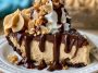 Chocolate peanut butter pie with a creamy peanut butter filling and rich chocolate topping, served in a slice with whipped cream.
