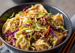 Noodle bowl with savory pork, cabbage slaw, and potsticker-style sauce.
