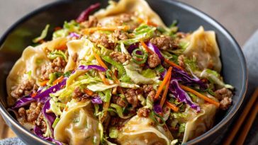 Noodle bowl with savory pork, cabbage slaw, and potsticker-style sauce.