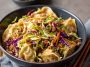 Noodle bowl with savory pork, cabbage slaw, and potsticker-style sauce.