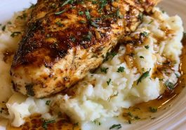 Juicy glazed garlic herb chicken breast served over creamy mashed potatoes with rich pan sauce drizzled on top.