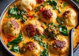 Coconut curry soup with dumplings, creamy broth, and aromatic herbs.