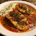 Tilapia fillets served in roasted red pepper sauce with herbs.