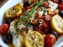 Mediterranean baked fish with herbs, lemon, tomatoes, and olive oil.