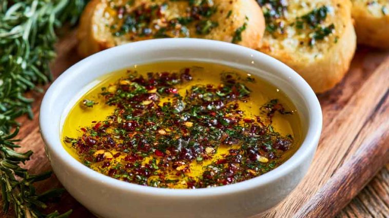 Bread dipping oil with herbs, garlic, and olive oil served with crusty bread.