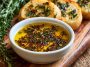 Bread dipping oil with herbs, garlic, and olive oil served with crusty bread.