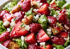 Fresh strawberry crackle salad with juicy strawberries, crunchy toppings, creamy dressing, and greens in a bowl.