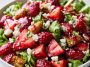 Fresh strawberry crackle salad with juicy strawberries, crunchy toppings, creamy dressing, and greens in a bowl.