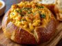 Creamy mac and cheese served inside a crusty bread bowl, rich and cheesy.