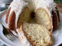Moist coconut cream cheese pound cake topped with shredded coconut and sliced to reveal a rich buttery texture.