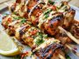 Bang bang chicken skewers glazed with creamy spicy sauce and grilled.
