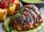 Roasted Peruvian chicken served with vibrant green sauce, crispy skin, and herbs on a plate.