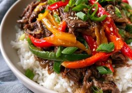 Healthy beef and pepper rice bowl with tender beef strips, colorful bell peppers, and fluffy rice, topped with fresh herbs.